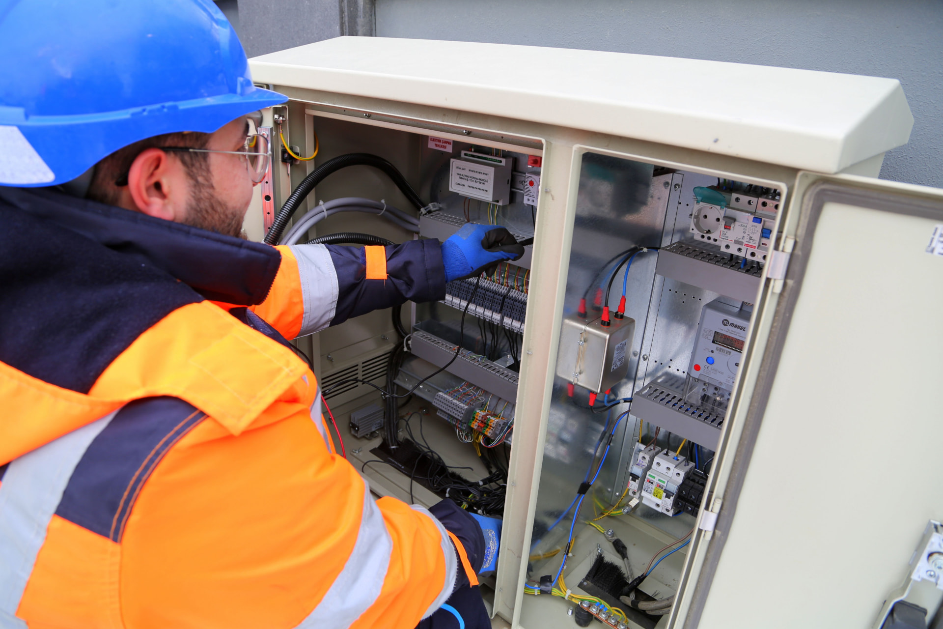 Profesionální elektrikář pracující s elektrickým panelem